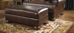 Signature Design By Ashley Axiom Walnut Ottoman - Madison Seating